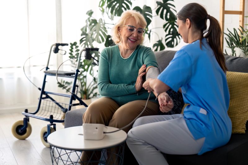 Healthcare provider taking blood pressure of elderly woman